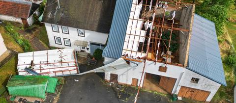 Bei einem Haus mit Scheune wurde das Dach abgedeckt. Aufnahme aus der Luft.