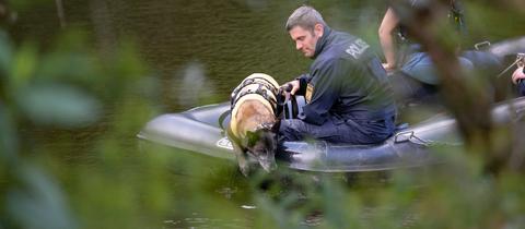 Mit einem Leichenspürhund suchen Polizeibeamte auf der Lahn von einem Boot aus nach der Leiche. 