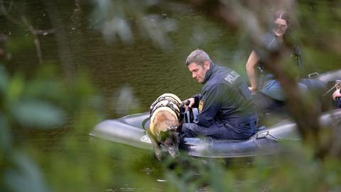Mit einem Leichenspürhund suchen Polizeibeamte auf der Lahn von einem Boot aus nach der Leiche. 