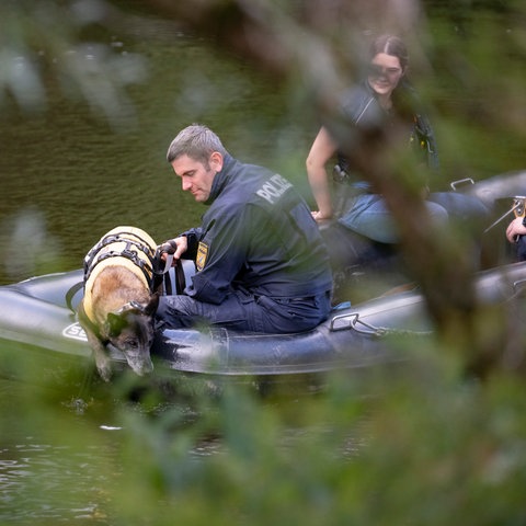 Mit einem Leichenspürhund suchen Polizeibeamte auf der Lahn von einem Boot aus nach der Leiche. 