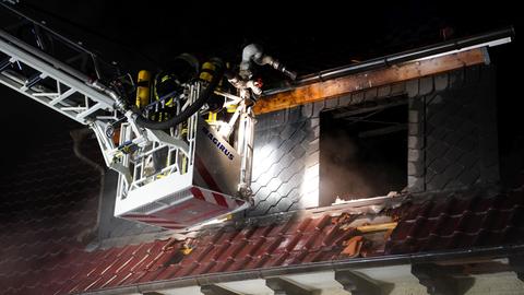 Feuerwehrleute auf Drehleiter am Dach