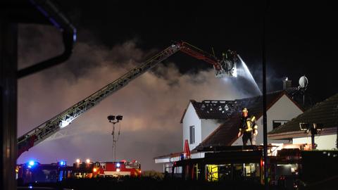 Feuerwehrleute löschen einen Wohnhausbrand in Wächtersbach in der Nacht zum Ersten Weihnachtsfeiertag