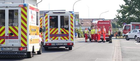 Rettungswagen und Feuerwehr auf einer Straße vor einem Gebäude