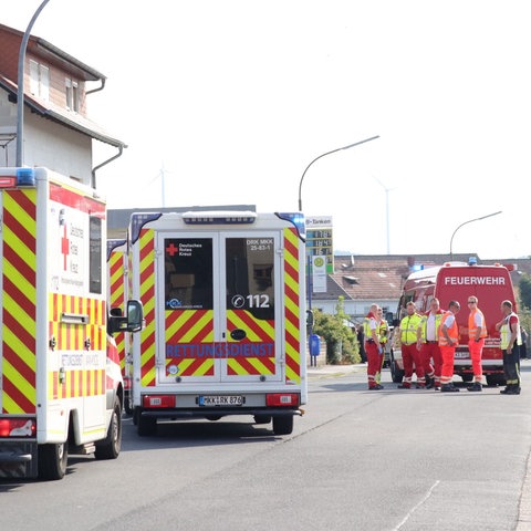 Rettungswagen und Feuerwehr auf einer Straße vor einem Gebäude