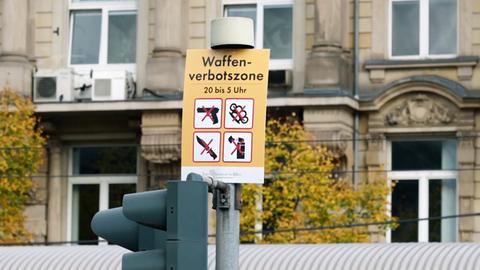Schild mit der Aufschrift "Waffenverbotszone" und entsprechenden Piktogrammen an einer Stange.