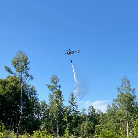 Hubschrauber wirft Löschwasser über Waldgebiet in Kassel ab