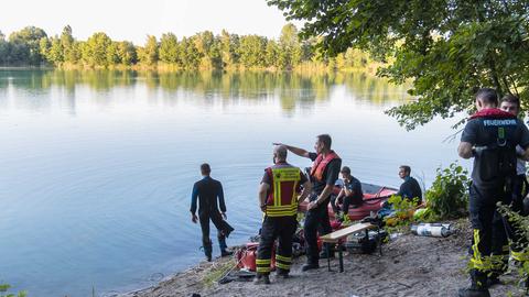 Einsatzkräfte von Rettungsdienst und Feuerwehr mit Schlauchoot am Ufer eines Sees.