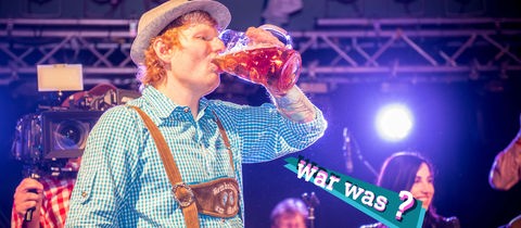 Ed Sheeran mit Lederhosen und Seppelhose und einer Maß Bier beim Oktoberfest in Franfurt