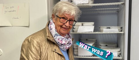 Foto von Gertrud Kirk (91) vor einem Kühlschrank im Keller der Altenselbsthilfe