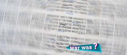 Foto von einem Blatt mit sehr vielen Zahlen. Nur die mittleren Zahlen sind scharf, um sie herum bildet sich kreisförmig eine Unschärfe, als würde sich das Bild drehen. Auf dem Bild eine kleine, farbige Grafik mit dem Schriftzug "war was?".