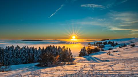 Sonne über Schnee-Landschaft im Panorama aufgenommen