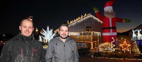 Zur blauen Stunde wird das Weihnachtshaus das erste Mal in dieser Saison in voller Beleuchtung gezeigt. Dominik Pieczko (l) und Sascha Bärwald haben für die prachtvolle Weihnachts-Illumination rund 65 000 LEDs verwendet.