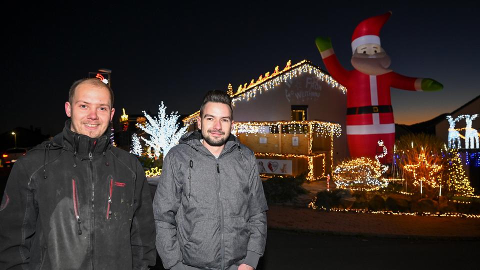 Zur blauen Stunde wird das Weihnachtshaus das erste Mal in dieser Saison in voller Beleuchtung gezeigt. Dominik Pieczko (l) und Sascha Bärwald haben für die prachtvolle Weihnachts-Illumination rund 65 000 LEDs verwendet.