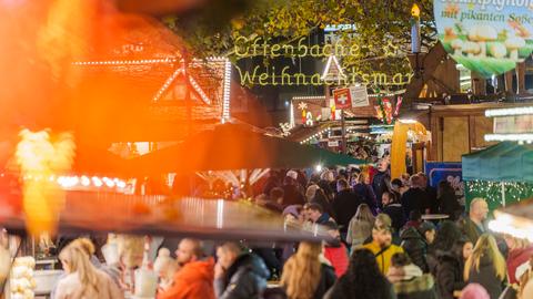 Besucher und Besucherinnen des Weihnachtsmarktes drängen sich in der Gasse zwischen den Buden.