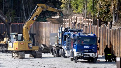 Baustelle mit Bauzaun, Bagger und einen LKW vom THW.