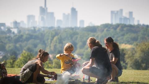 Eine Familie grillt vor der Frankfurter Skyline.