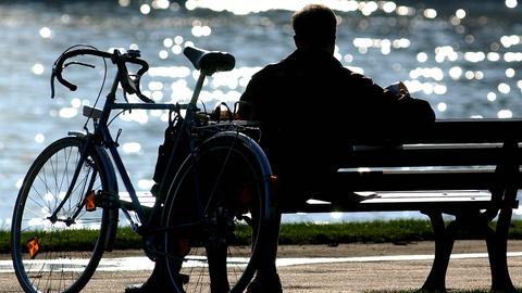 Radfahrer auf einer Bank am Main