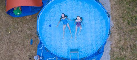 Ein Pool im Garten mit zwei Kindern im Wasser