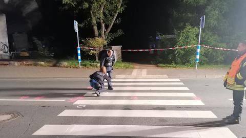 Polizisten machen Markierungen auf einem Zebrastreifen