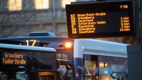 Busse stehen hinter einer elektronischen Fahrplan-Anzeige in Wiesbaden.