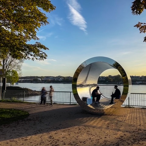 Die röhrenförmige Skulptur "Pixelröhre" am Rheinufer des Wiesbadener Stadtteils Kastel im Licht der herbstlichen Abendsonne.