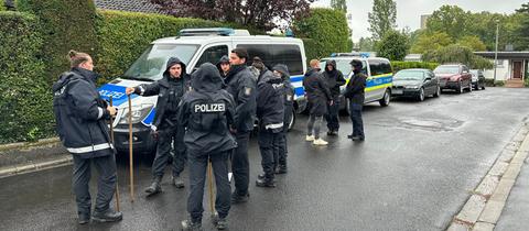 Polizisten in einer Wohnsiedlung mit Autos