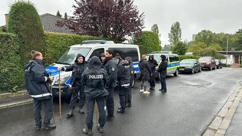 Polizisten in einer Wohnsiedlung mit Autos
