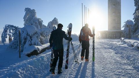 Skifahrer tragen ihre Ski auf dem Ettelsberg