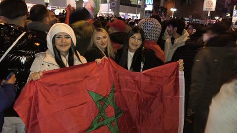 Drei marokkanische Fans halten die Fahne hoch.