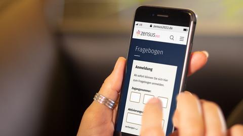 Eine Frau hat den Fragebogen auf ihrem Smartphone geöffnet.