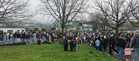 Menschen warten vor dem Stadion in Marburg.