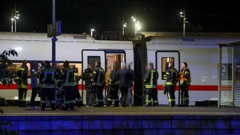 An einem Bahnsteig steht ein ICE-Zug. Auf dem Bahnsteig eine Gruppe von Feuerwehrleuten, dazwischen einzelne Passagiere.