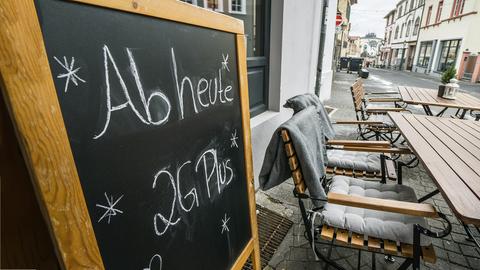 Auf einer Tafel im Außenbereich eines gastronomischen Betriebes steht "Ab heute nur noch 2 G Plus" geschrieben.