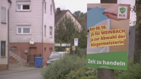 Plakat mit der Aufschrift "Am 08.10. JA für WEINBACH Ja zur Abwahl der Bürgermeisterin - Zeit zu handeln" 