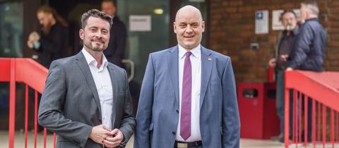 Die beiden Vorstandssprecher der hessischen Alternative für Deutschland (AfD), Andreas Lichert (l) und Robert Lambrou (r), stehen am Rande des Landesparteitages der AfD nach ihrer Wahl vor der Halle im Frankfurter Stadtteil Zeilsheim