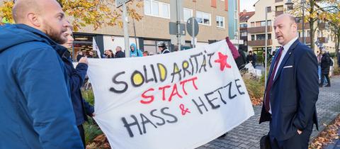 AfD-Co-Landeschef Robert Lambrou (r.) vor dem Landesparteitag im Gespräch mit Gegendemonstranten