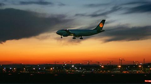 Flugzeug fliegt nachts auf Flughafen Frankfurt zu