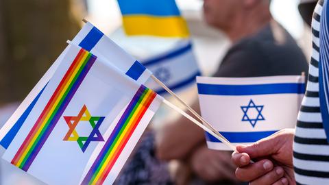 Die israelische Flagge mit Davidstern, eine israelische Flagge in Regenbogenfarben und eine ukrainische Flagge sind auf der Veranstaltung „Frankfurt vereint gegen Antisemitismus“ zu sehen.