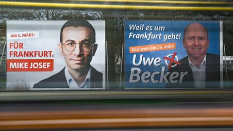 Auf zwei Plakaten, die nebeneinander aufgestellt sind, sind die beiden Kandidaten Mike Josef und Uwe Becker abgebildet.