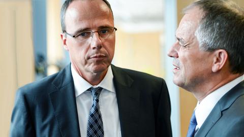 Foto: Peter Beuth (Innenminister) und Gerhard Bereswill (Polizeipräsident) im Gespräch. Sie stehen und ihre Oberkörper und nachdenklichen Gesichter sind zu sehen.