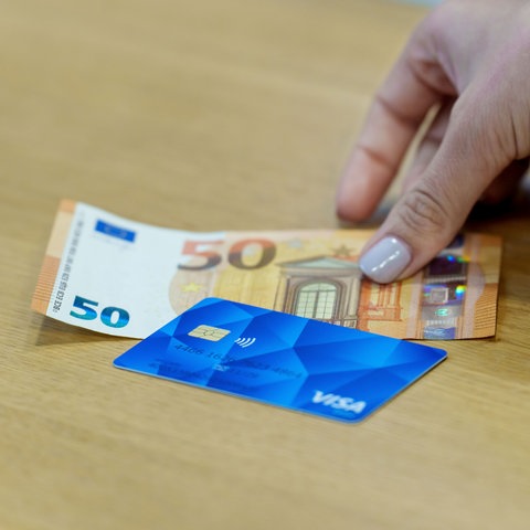 Poszukiwacze azylowe i karta płatnicza z certyfikatem 50 euro są obok siebie. 
