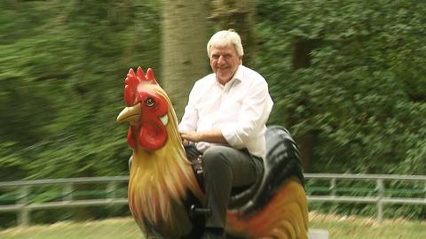 Volker Bouffier auf einem Hahnen-Karussell