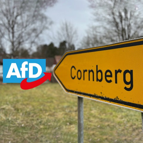 Ein Ortsschild von Cornberg zeigt bei einer Foto-Montage mit der Spitze auf das Parteilogo der AfD. 