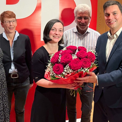 Isabel Carqueville erhält nach ihrer Nominierung rote Blumen und hält sie in den Händen.