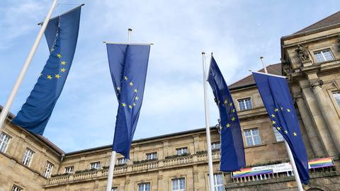 Vor einem historischen Gebäude wehen vier EU-Fahnen im Wind.