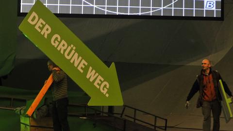 Ein grüner Pfeil auf einer Wahlveranstaltung zeigt nach unten.