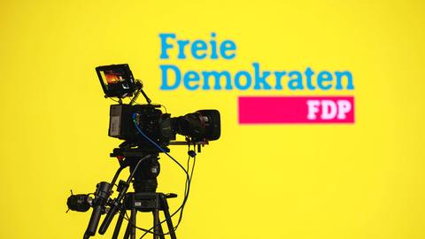 Eine Kamera zeigt auf ein FDP-Logo