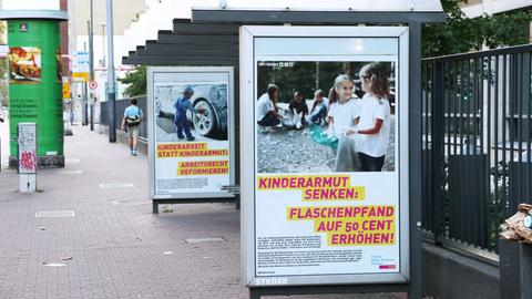 Zwei satirische FDP-Plakate hängen in Schaukästen an einer Haltestelle