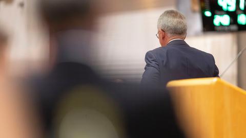 Feldmann dreht den Rücken zur Kamera und verlässt das Podium. 