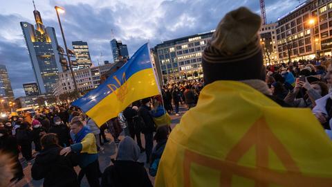 Teilnehmer stehen am Donnerstagabend zur Unterstützung der Ukraine an der Hauptwache in Frankfurt.